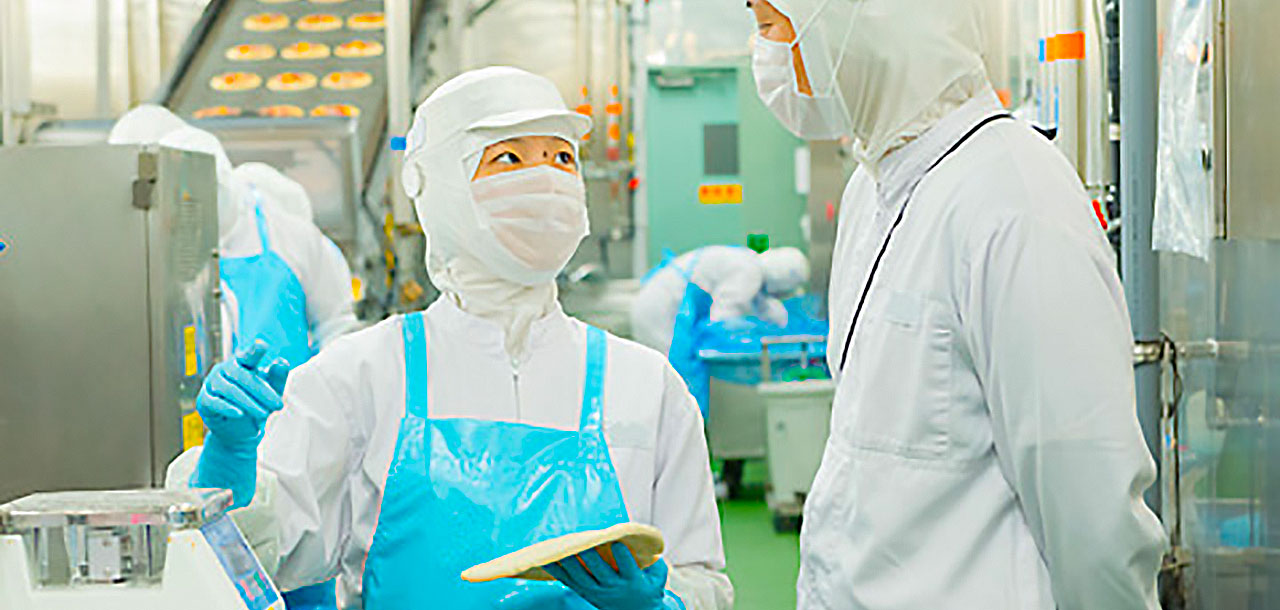 衛生管理された食品工場で会話する従業員